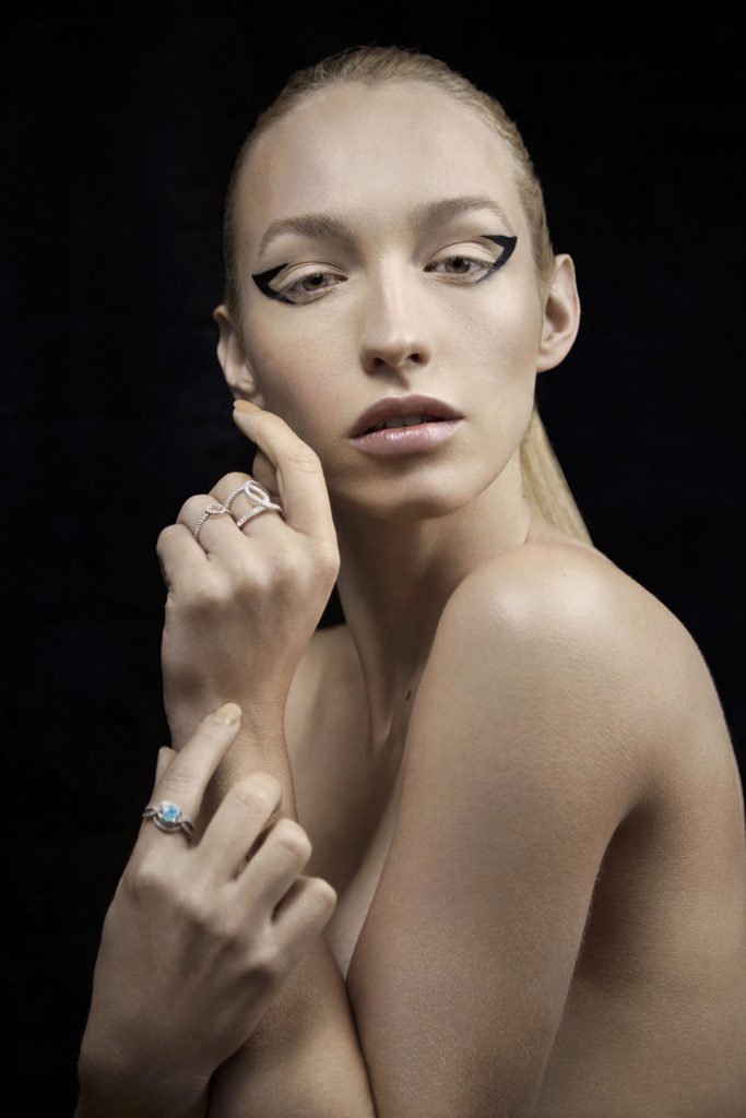 Topless model with black avant-garde eye make-up.