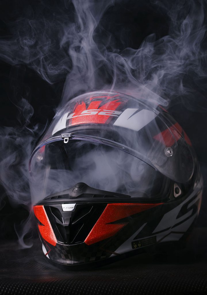 Photo of red and black motorbike helmet with smoke.