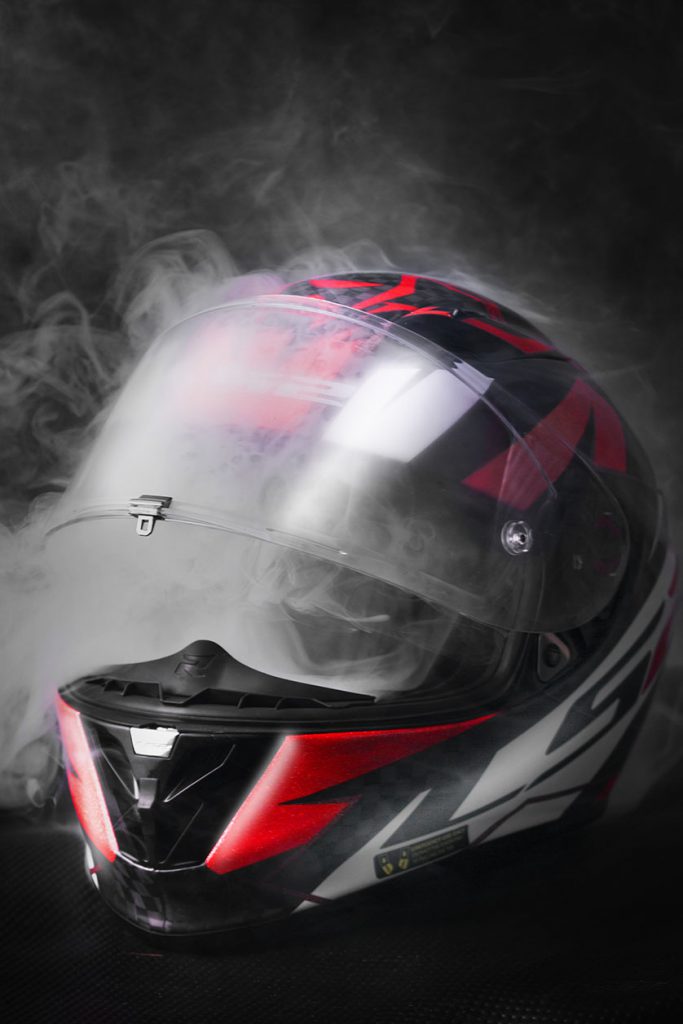 Photo of red and black motorbike helmet with smoke.